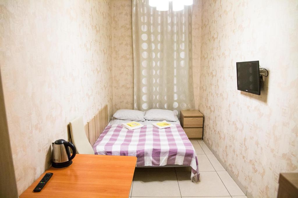 a small bedroom with a bed and a table at Bolshaya Morskaya 7 in Saint Petersburg