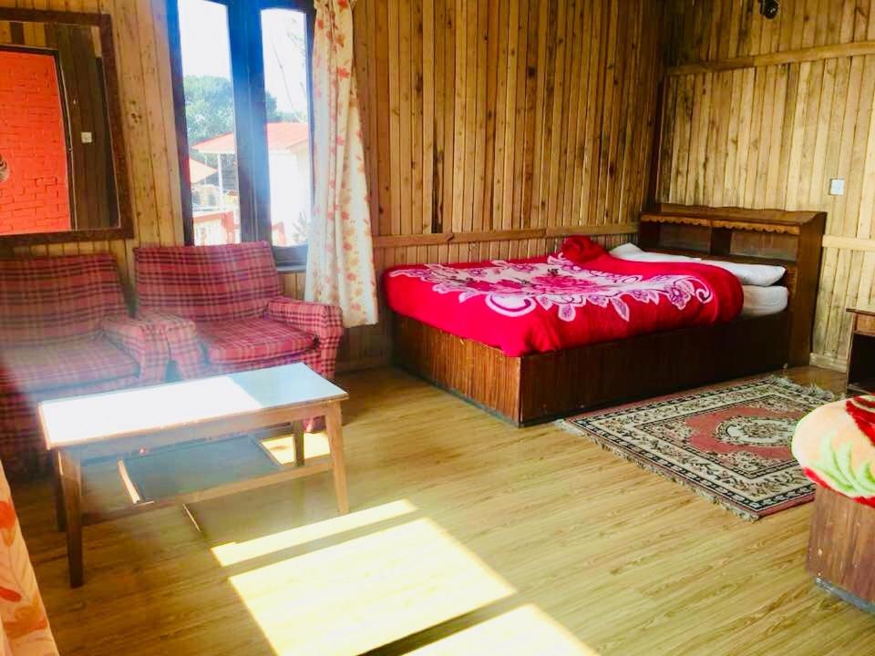 a living room with a red bed and a couch at Hotel Galaxy View Tower in Nagarkot