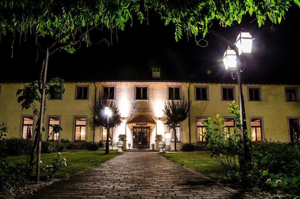 a building at night with a cobblestone driveway at Bes Hotel Bergamo Cologno al Serio in Cologno al Serio
