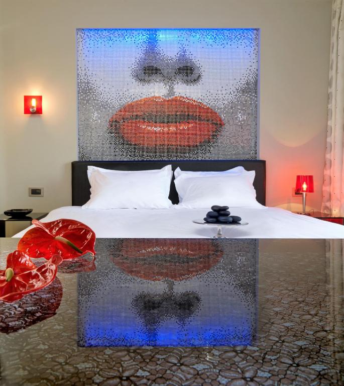 a bedroom with a bed with a painting of a lips at Out Of The Blue Resort & Spa in Agia Pelagia