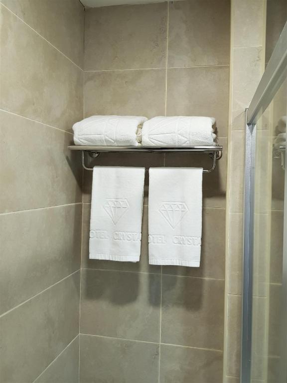 un bagno con asciugamani bianchi su una mensola di Crystal Resort a Bakuriani