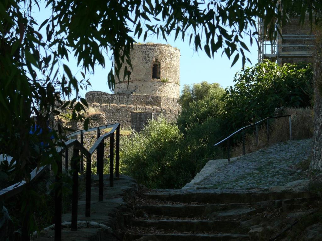 an old stone building with stairs leading up to it at Camino del Castillo in Jimena de la Frontera