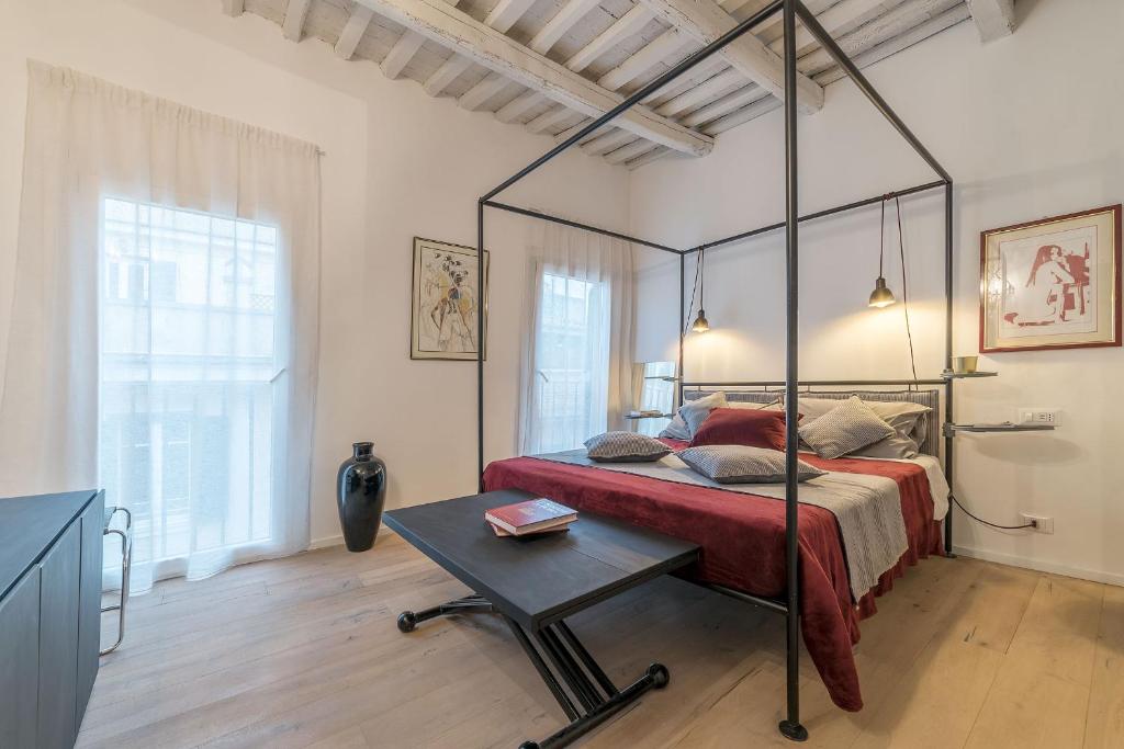 una camera con letto a baldacchino e tavolo di Colosseum Exclusive Duplex a Roma