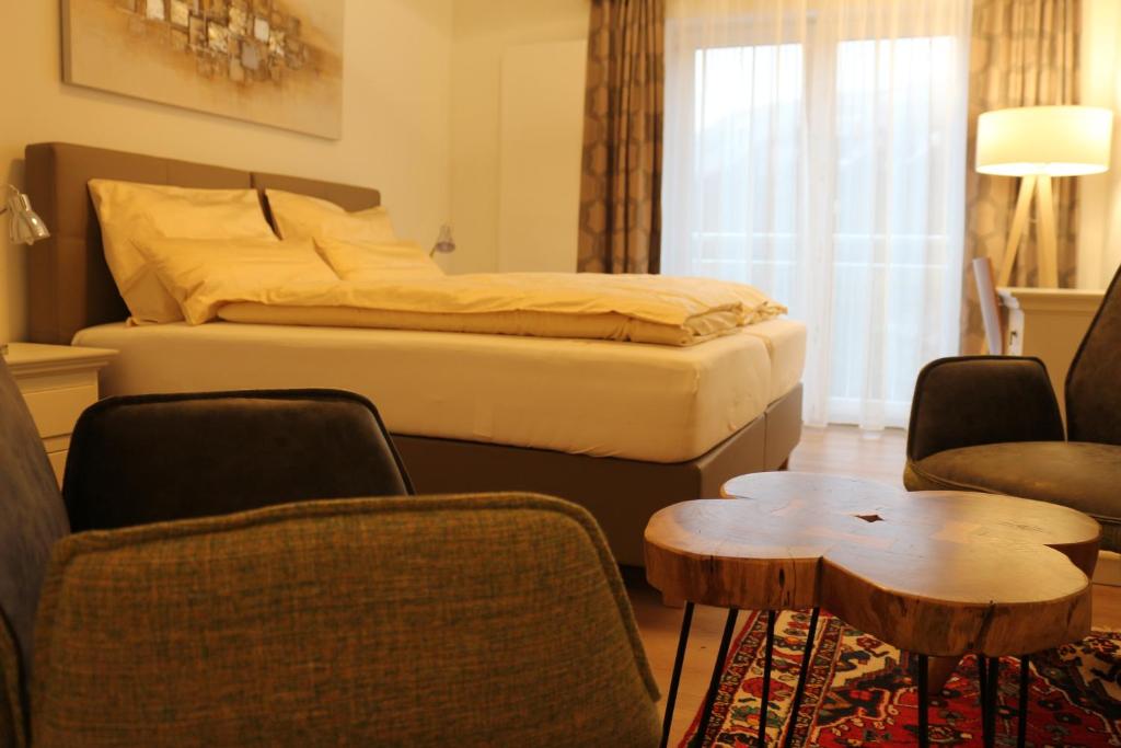 a hotel room with a bed and chairs and a table at Gasthof Eckberg in Unzmarkt