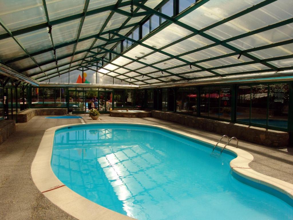 une grande piscine avec un plafond en verre dans l'établissement Bungalows Peña Montañesa, à Aínsa