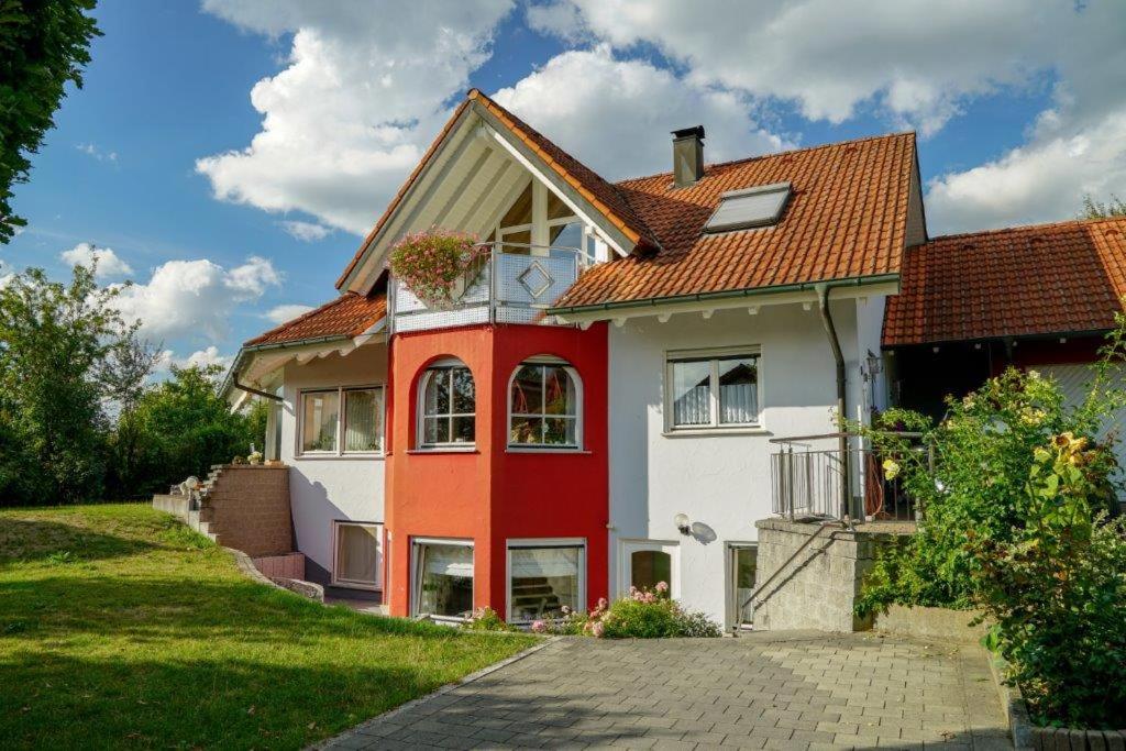 une maison rouge et blanche avec un toit rouge dans l'établissement Ferienwohnung Roth, à Frickingen