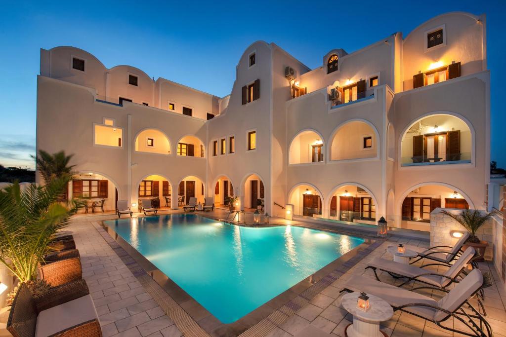 - un grand bâtiment avec une piscine en face dans l'établissement Astir Thira Hotel, à Fira