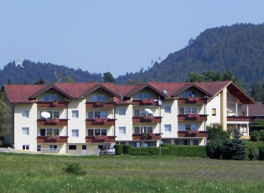 a large hotel with a mountain in the background at Apartments Kleinseeblick in Sankt Kanzian