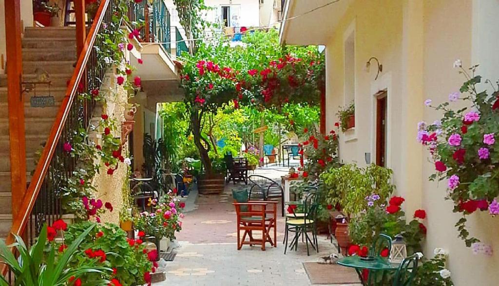 eine Gasse voller Blumen, Tische und Stühle in der Unterkunft Villa Manolis in Tolo