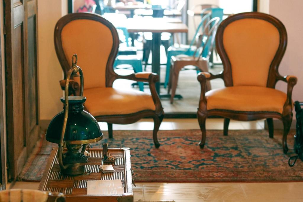 a room with two chairs and a table with a lamp at 352 Guest House Hotel Boutique in San Juan