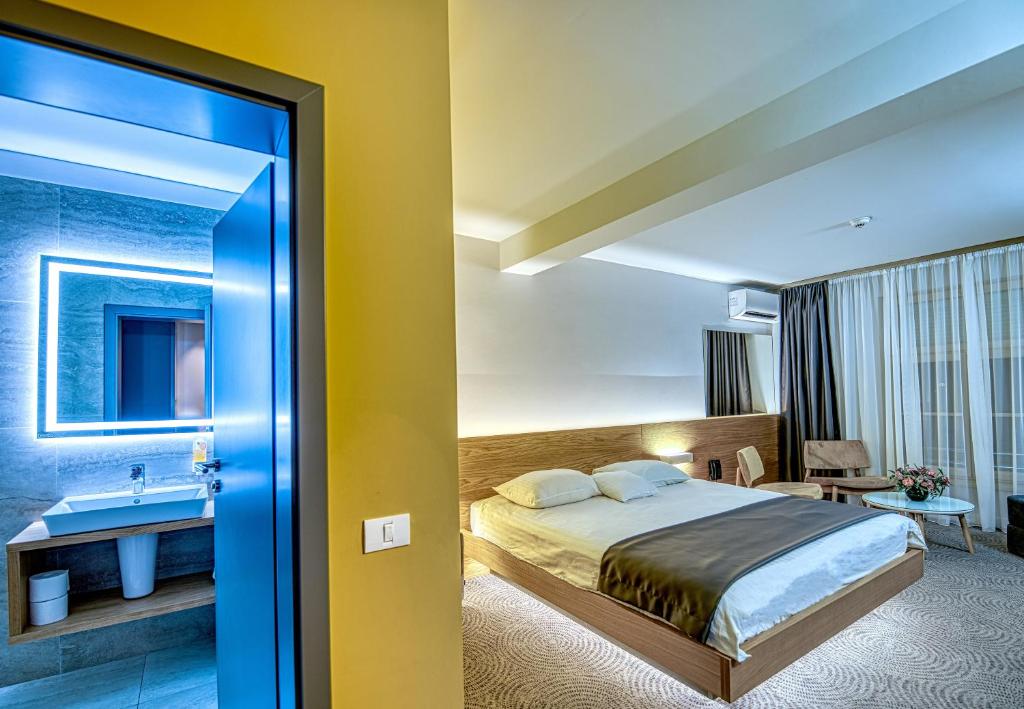 ティミショアラにあるHotel Silvaのベッドとシンク付きのホテルルーム