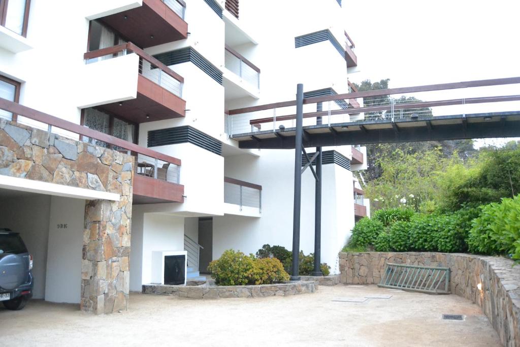 a building with a car parked in a parking lot at Departamento Maitencillo Costamai in Maitencillo