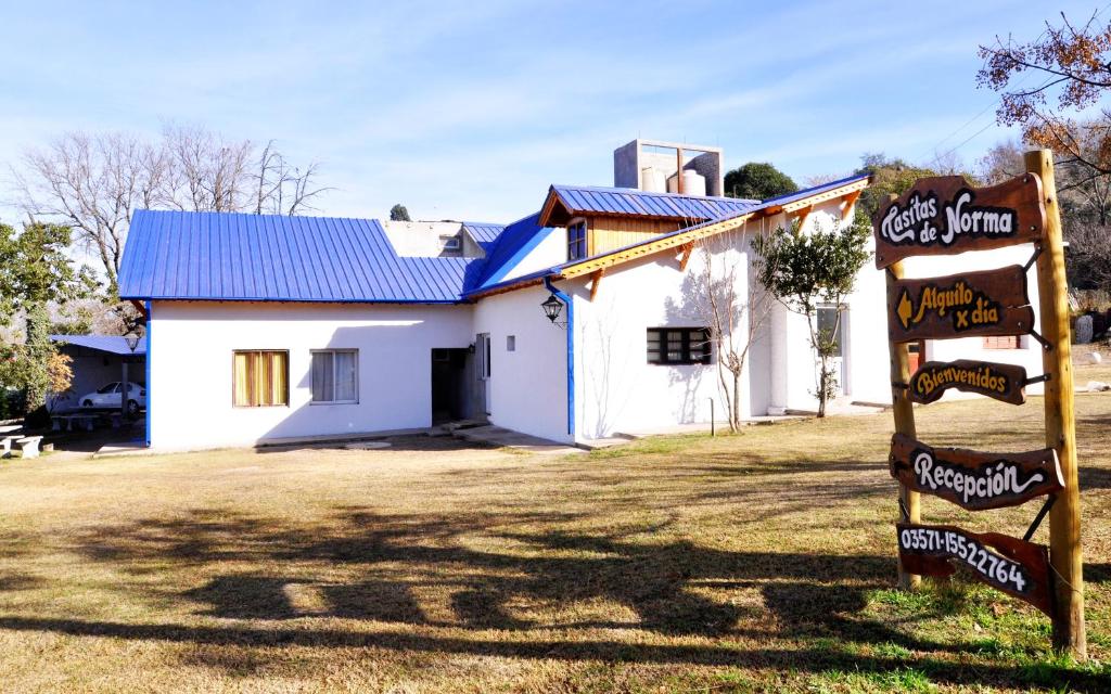 un bâtiment blanc avec un panneau devant lui dans l'établissement Casitas de Norma, à Embalse