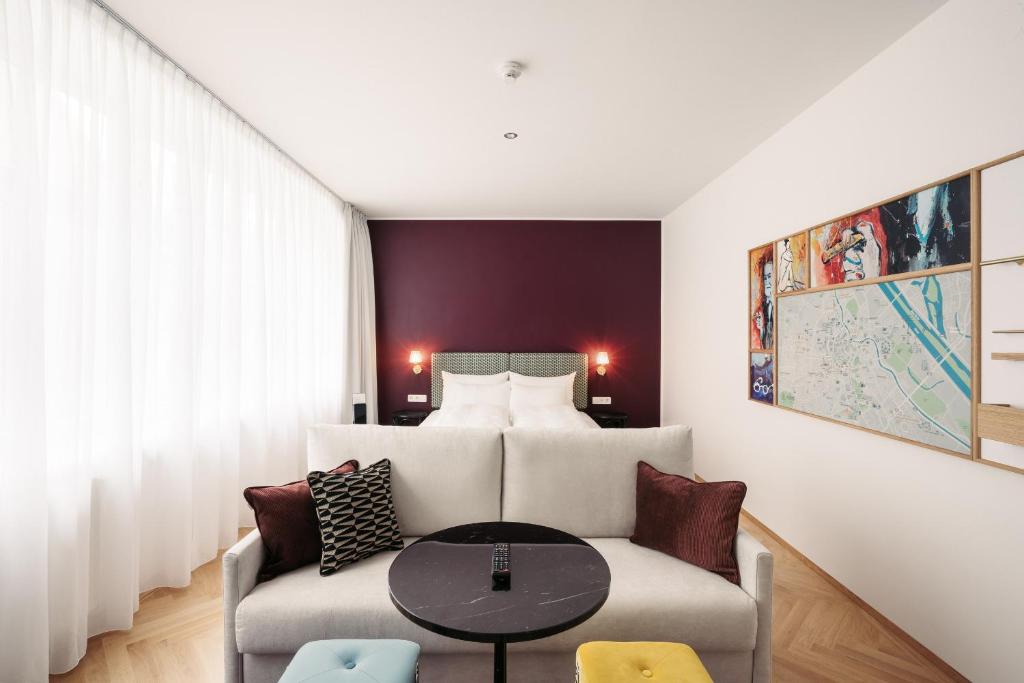 ein Wohnzimmer mit einem Sofa und einem Bett in der Unterkunft Hotel Schani Salon in Wien