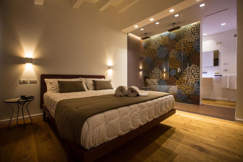 カターニアにあるPlebis - B&B in Sicilia nel centro storico di Cataniaの大きなベッド付きのベッドルーム1室、壁に絵画が飾られています。