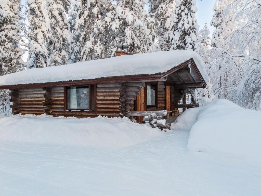 ユッラスヤルヴィにあるHoliday Home Kurtakko pekka by Interhomeの森の雪に覆われた丸太小屋
