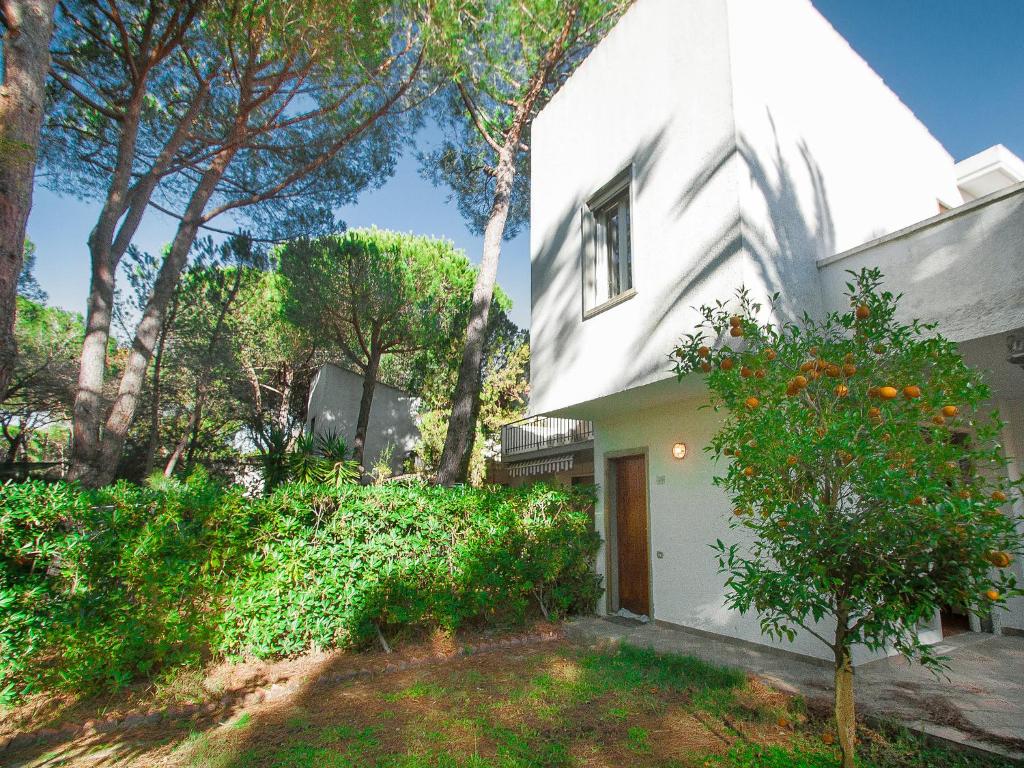 Una casa blanca con un árbol delante. en Holiday Home Casa Polipo by Interhome, en Principina a Mare