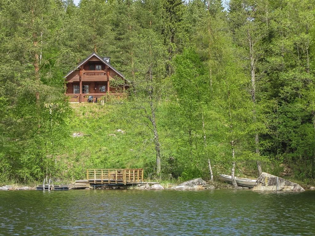 uma cabana de madeira numa colina junto a um lago em Holiday Home Etelärinne by Interhome em Vuoriniemi