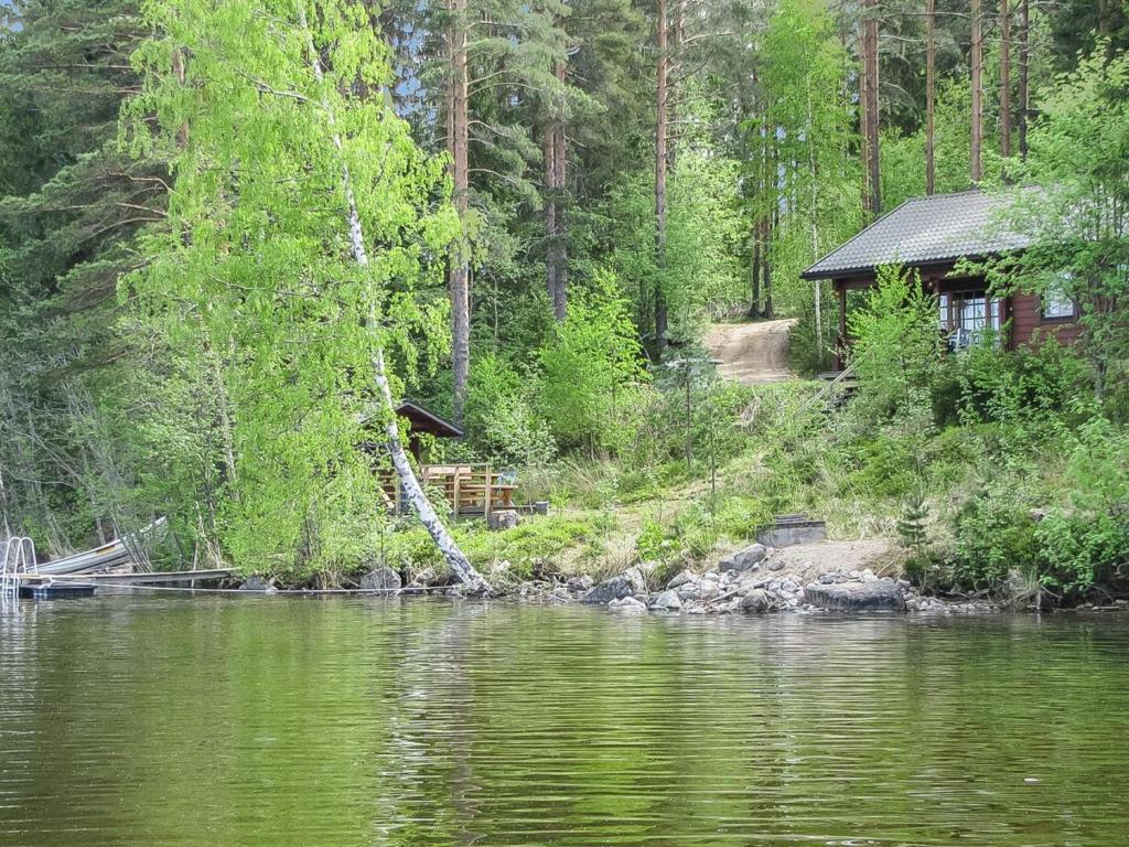 une cabine sur la rive d'un lac à côté d'une forêt dans l'établissement Holiday Home Illanvirkku by Interhome, à Vuoriniemi