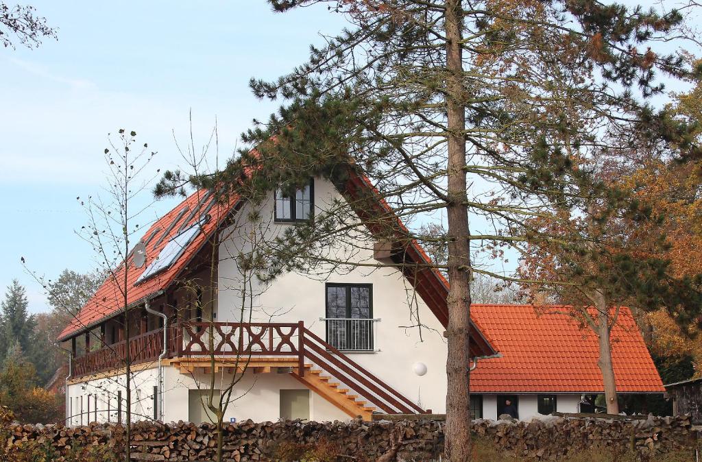 ein großes weißes Haus mit orangefarbenem Dach in der Unterkunft Ferienwohnungen Zum Baumhaus in Burg
