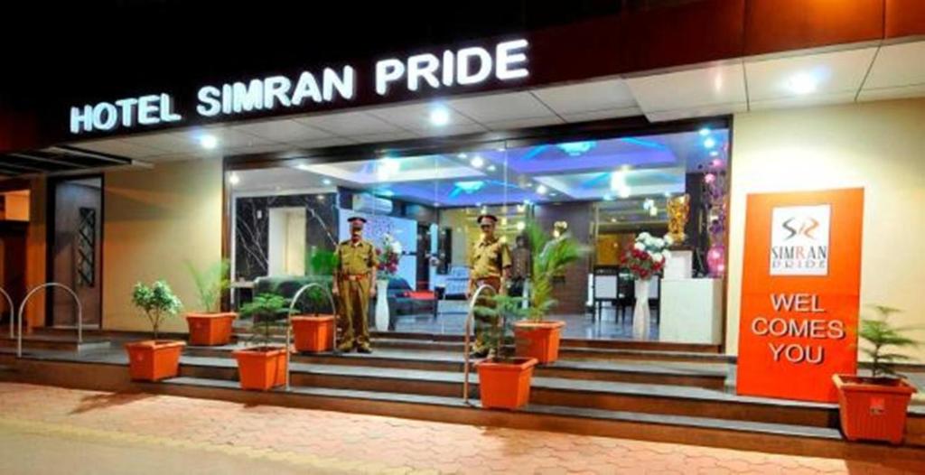 a hotel with two men standing in front of a building at Hotel Simran Pride, Raipur in Raipur