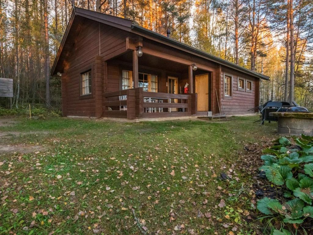 a log cabin in the woods with a yard at Holiday Home Aurinkorinne by Interhome in Vuoriniemi