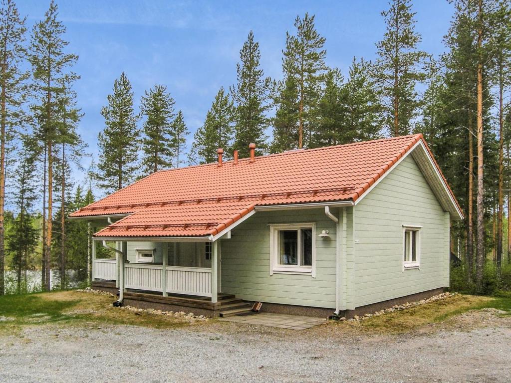 a small green house with an orange roof at Holiday Home Yläneuvola lanssi by Interhome in Neuvola