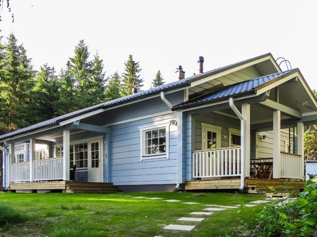 a small blue house with a front porch at Holiday Home Kuutti by Interhome in Vuoriniemi