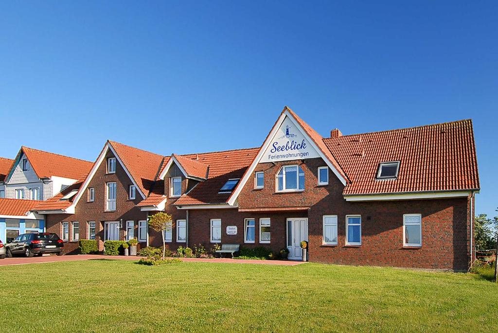 un gran edificio de ladrillo con un cartel. en Ferienwohnungen Haus Seeblick, en Carolinensiel