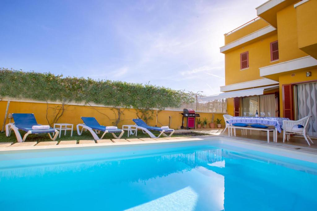 una piscina con sedie blu e una casa di Villa Isabel a Playa de Palma