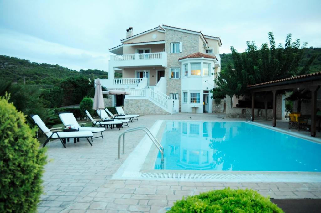 een villa met een zwembad en een huis bij Bella Villa in Vaia