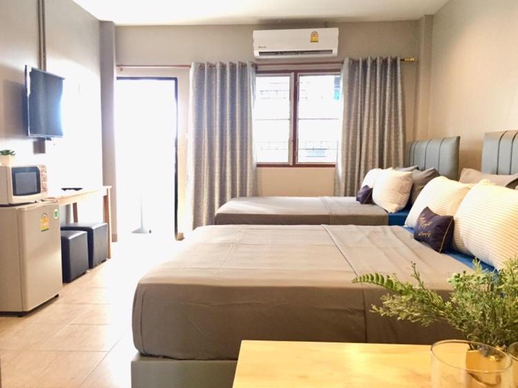 Habitación de hotel con 2 camas y mesa en R9 Bangkok en Bangkok