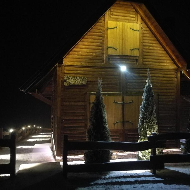 a wooden cabin with a light on the door at night at Lodge Nagramak in Sekulić 