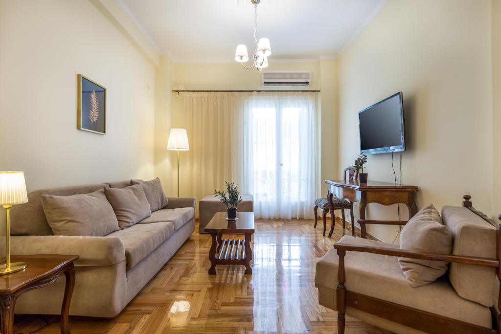 a living room with a couch and a tv at Chic flat in Kolonaki next to American Embassy in Athens