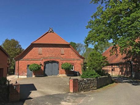 a red brick building with a large garage at Ferienwohnung Am Sod - Familie Hennig in Rullstorf