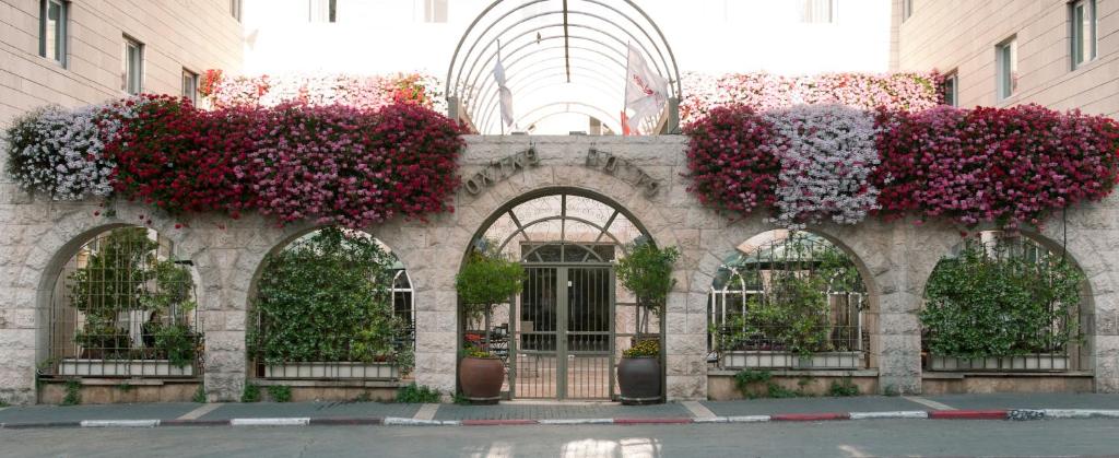 un edificio con flores a un lado. en Prima Palace Hotel, en Jerusalén