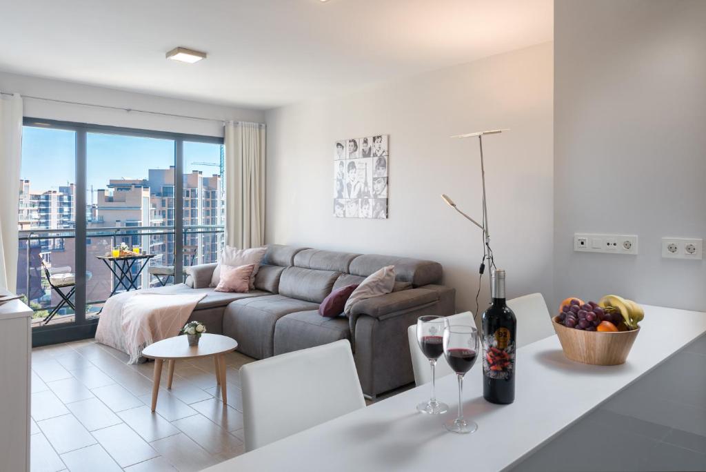 a living room with a couch and a table with wine glasses at Playa & Golf in Alicante