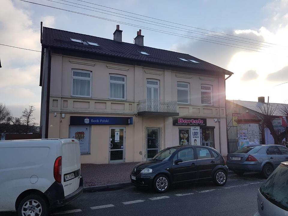 una furgoneta blanca estacionada frente a un edificio en Pokoje nad Drzewiczką, en Drzewica