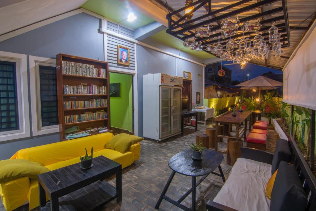 salon z żółtą kanapą i stołami w obiekcie Relax Resort Angkor Villa w Siem Reap