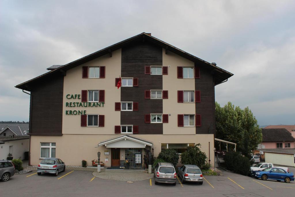 a large building with cars parked in a parking lot at Landgasthof Krone Bed & Breakfast in Sankt Gallenkappel