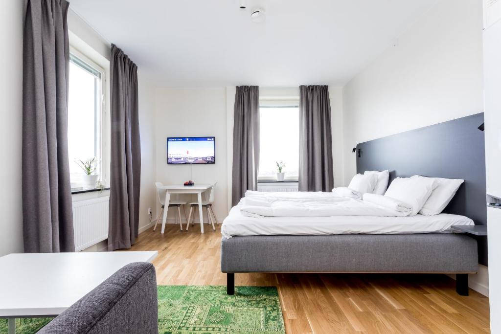 une chambre d'hôtel avec un lit et un canapé dans l'établissement ApartDirect Linköping Arena, à Linköping