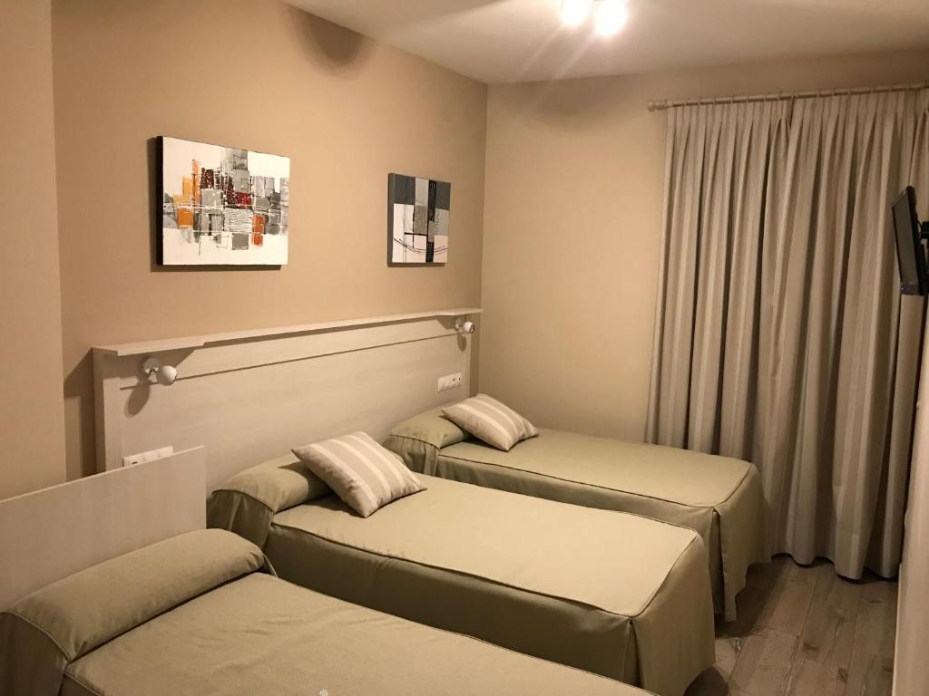 ビジャヌエバ・デ・コルドバにあるHostal Los Encinaresのベッド2台と窓が備わる客室です。