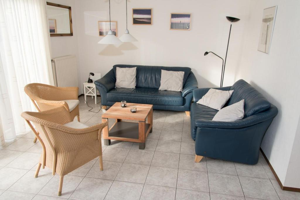 Sala de estar con 2 sofás y mesa en Hello Zeeland - Vakantiehuis Zwin 218, en Breskens