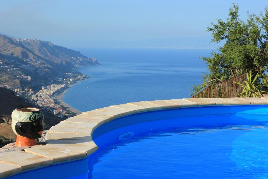 ein Swimmingpool mit Blick auf das Meer in der Unterkunft Villa Almoezia Charming B&B in Taormina