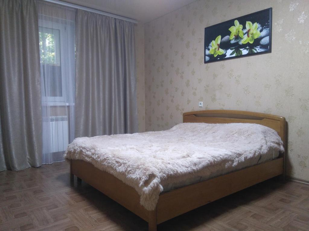 1 dormitorio con cama y ventana en Просторная 1комнатня квартира напротив ТРЦ Дафи Ашан рядом ресторан Альтбир, en Járkov