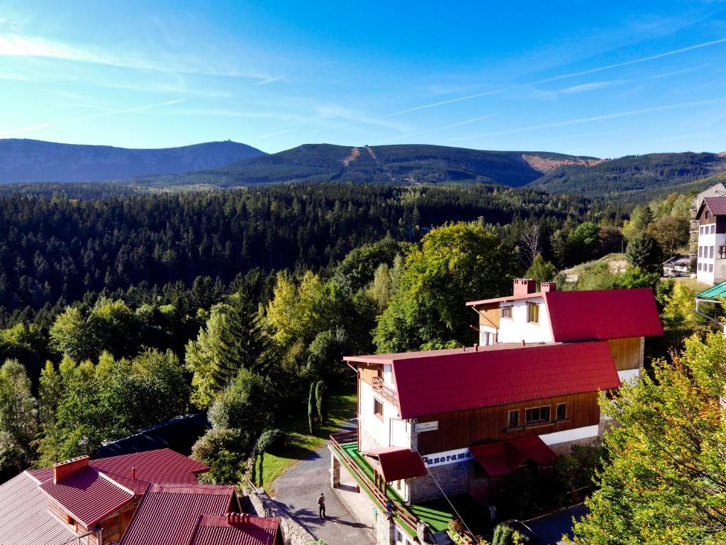 una casa con techo rojo con montañas al fondo en Panorama Gór w Karpaczu en Karpacz