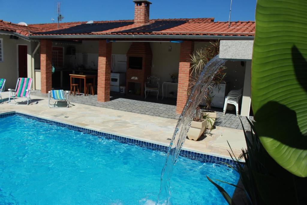 una piscina con sillas azules y una casa en Casa de São Pedro en São Pedro