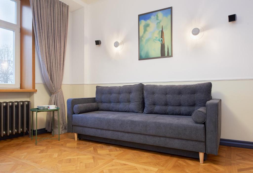 a couch sitting in a living room next to a window at Town Hall Apartments in Vilnius