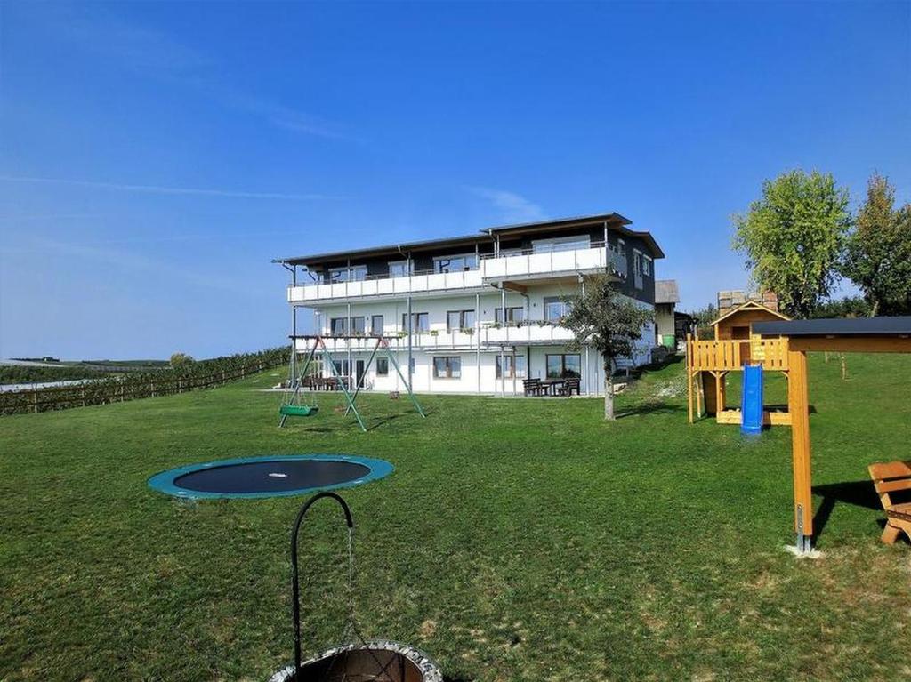 a large building with a playground in the yard at Ferienhof Raither in Immenstaad am Bodensee