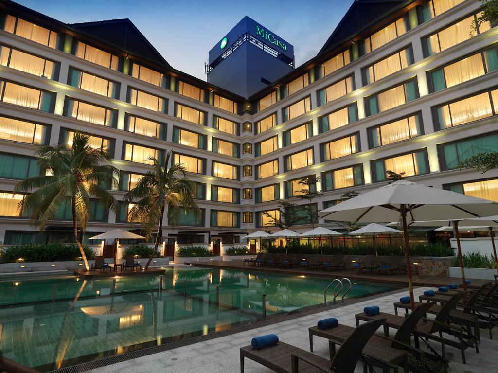 a hotel with a swimming pool in front of a building at Micasa All Suites Hotel in Kuala Lumpur